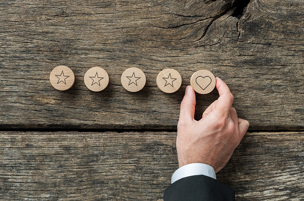 four wood discs with stars, a hand holding a disc with a heart